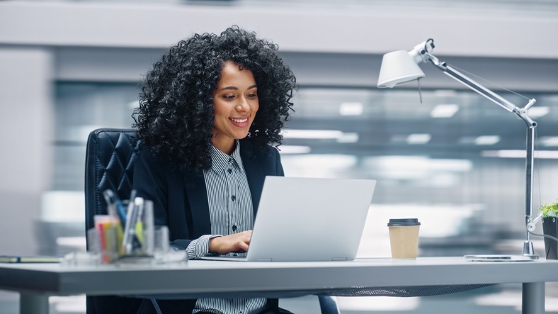 Empresária atraente e bem-sucedida usando um tablet digital em frente ao prédio comercial. Conceito de trabalho de pessoas de negócios.